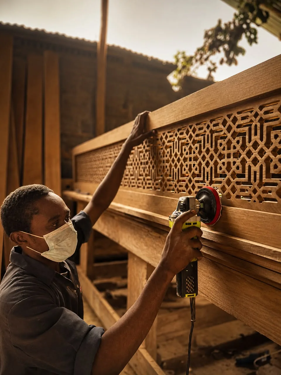 Zagalo craftsman sanding a carved timber screen panel